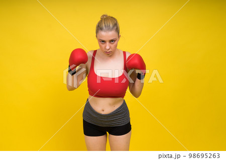 Seductive confident female boxer with gloves studio, sporty woman posing looking at camera. Seductive confident female boxer with gloves studio, sporty woman posing looking at camera. 98695263