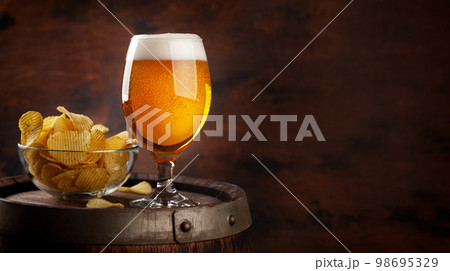 Beer glass on wooden barrel 98695329