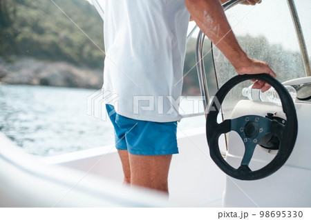 Man drives a motor boat in the sea.  98695330