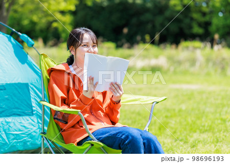 ソロキャンプで読書をする若い女性 98696193