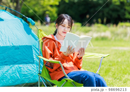 ソロキャンプで読書をする若い女性 98696213