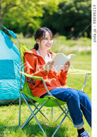 ソロキャンプで読書をする若い女性 98696214