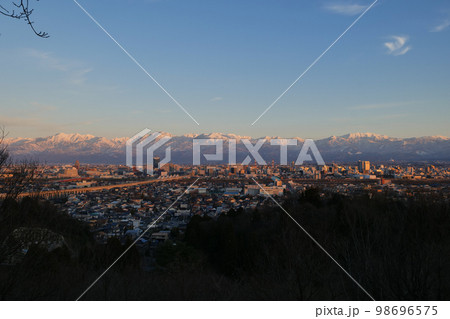 パノラマ富山市全景呉呉羽山から見る雪を頂く北アルプス薬師岳、立山連峰、剱岳、毛勝山冬の夕景 98696575