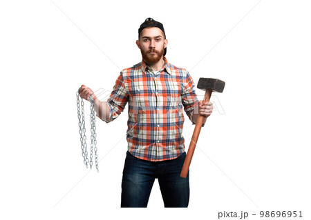 Serious bearded man in cap and checked shirt, holds hammer and chains in hands on white background Serious bearded man in cap and checked shirt, holds hammer and chains in hands on white background 98696951