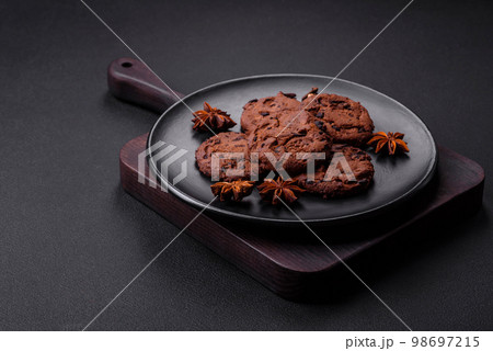Delicious chocolate cookies with nuts on a black ceramic plate 98697215