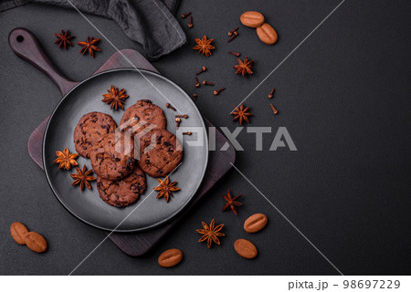 Delicious chocolate cookies with nuts on a black ceramic plate Delicious chocolate cookies with nuts on a black ceramic plate 98697229