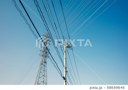 交差する住宅街の電線と高圧送電線と快晴の空　b-5 暖色加味 98699646