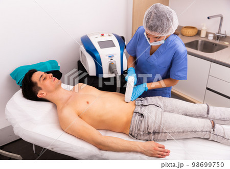 Male client receiving hardware hair removal treatment 98699750