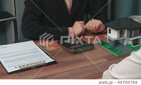 Closeup enthusiastic customer review contract paperwork for house loan. Closeup enthusiastic customer review contract paperwork for house loan. 98700768