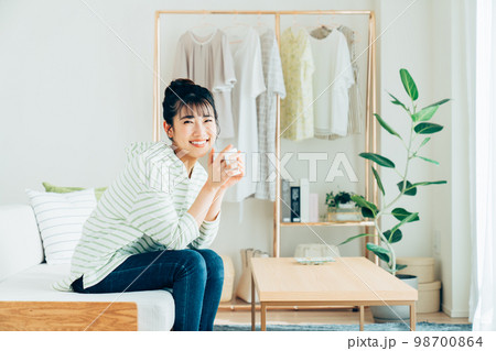 リビングで寛ぐ若い女性 98700864
