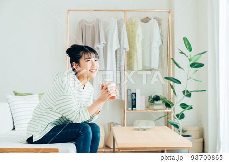 リビングで寛ぐ若い女性 98700865