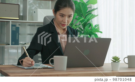 Enthusiastic businesswoman working and typing laptop in the office. 98701048