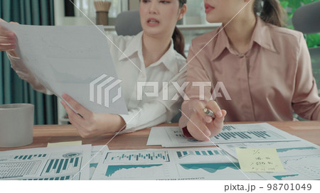 Two young enthusiastic businesswoman working together in the office workspace. 98701049