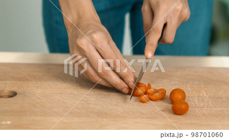 Close up hands holding a knife preparing a contented meal. Close up hands holding a knife preparing a contented meal. 98701060