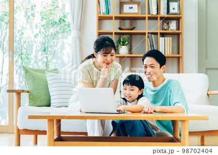 リビングでパソコンを見る家族 リビングでパソコンを見る家族 98702404