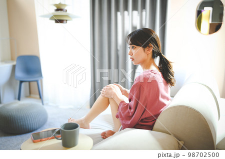 自宅で過ごす20代の女性 自宅で過ごす20代の女性 98702500