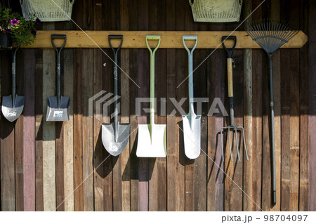 Gardening tools hang on Wooden wall, tool concept Gardening tools hang on Wooden wall, tool concept 98704097