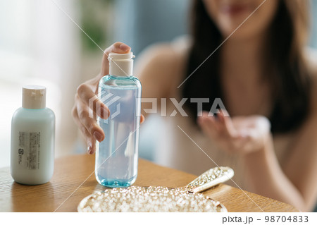 スキンケアをする女性・化粧水をつける女性 スキンケアをする女性・化粧水をつける女性 98704833