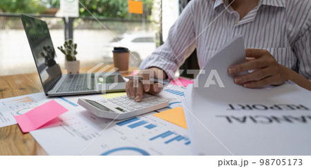 Close up usiness woman using calculator and laptop for do math finance on wooden desk in office and business working background, tax, accounting, statistics and analytic research concept 98705173
