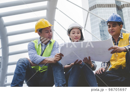 Civil Construction engineer teams shaking hands together wear work helmets worker on construction site. Foreman industry project working engineer teamwork. Two asian engineer team shake hands together 98705697