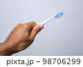 Hand holding toothbrush isolated on gray background . Toothbrush concept. 98706299