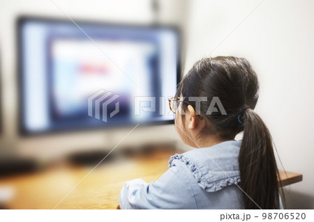 パソコンモニターで動画配信を見る子供の女の子 98706520