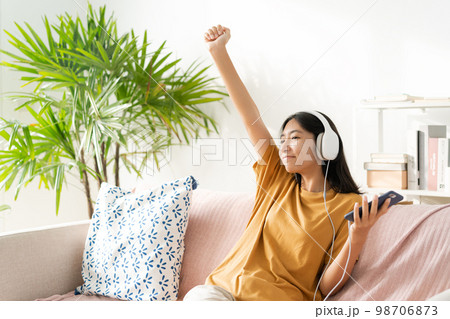 Asian teenager listening to music on smartphone with headset enjoy.  98706873