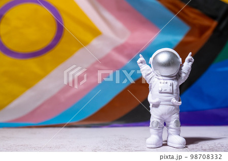 Toy astronaut on Rainbow LGBTQIA flag made from silk material background. Happy pride month. Symbol of LGBTQ pride month. Equal rights. Peace and freedom. Support LGBTQIA community Toy astronaut on Rainbow LGBTQIA flag made from silk material background. Happy pride month. Symbol of LGBTQ pride month. Equal rights. Peace and freedom. Support LGBTQIA community 98708332