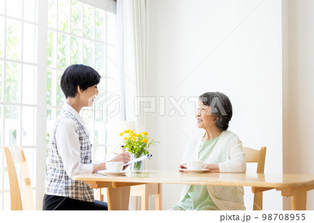 シニア夫婦に説明をする女性 シニア夫婦に説明をする女性 98708955