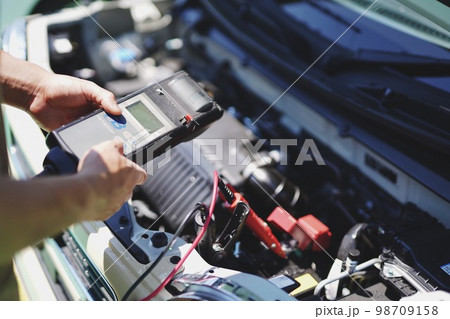 バッテリー充電量を測定する自動車整備士 98709158