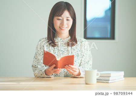 読書をしながらティータイムを楽しむ女性 読書をしながらティータイムを楽しむ女性 98709344