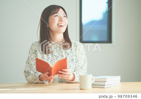 読書をしながらティータイムを楽しむ女性 読書をしながらティータイムを楽しむ女性 98709346