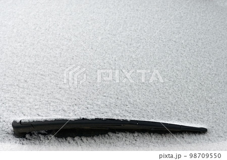 Snowy windshield on a car with wipers. Winter concept for traffic and road safety. 98709550