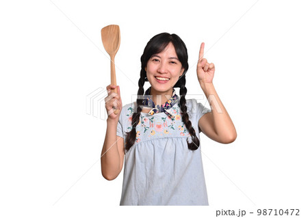 Portrait of beautiful young asian woman smile in denim dress with spatula on white background Portrait of beautiful young asian woman smile in denim dress with spatula on white background 98710472