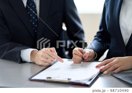 契約内容を確認するアジア人ビジネスパーソン 98710490