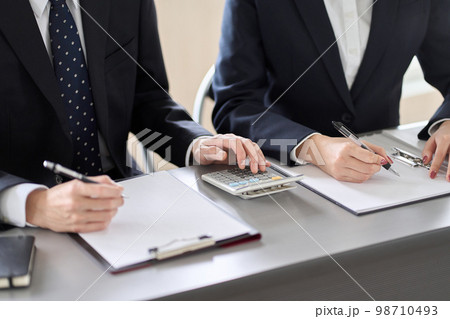 ヒアリングを行うアジア人の士業の手元 98710493