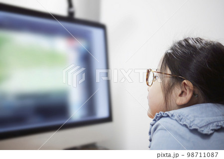 パソコンモニターで動画配信を見る子供の女の子 パソコンモニターで動画配信を見る子供の女の子 98711087