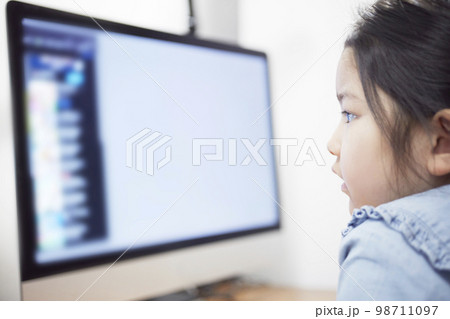 パソコンモニターで動画配信を見る子供の女の子 98711097