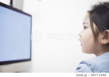 パソコンモニターで動画配信を見る子供の女の子 98711098
