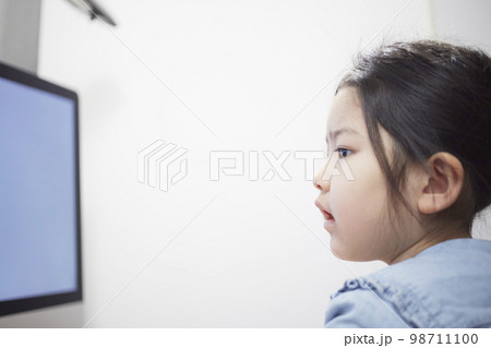 パソコンモニターで動画配信を見る子供の女の子 98711100