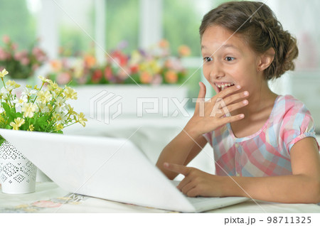 Emotional surprised cute girl using laptop at home 98711325