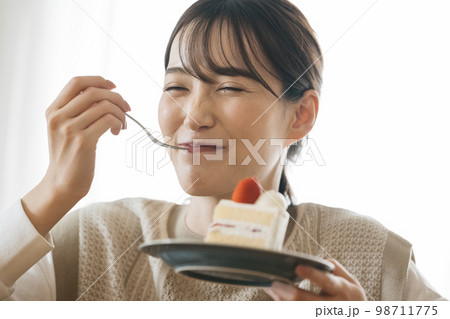 ショートケーキを食べる女性 98711775