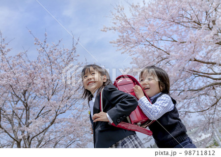 桜の咲く遊歩道を歩く入学入園の姉弟 桜の咲く遊歩道を歩く入学入園の姉弟 98711812