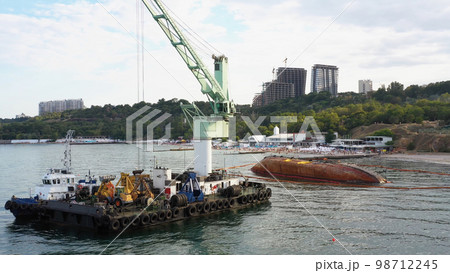 Rescue wrecked oil tanker ship in Odessa. Old rusty ship lie on its side aground. Black Sea coast. Rescue wrecked oil tanker ship in Odessa. Old rusty ship lie on its side aground. Black Sea coast. 98712245