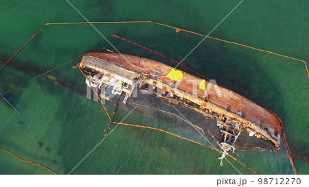 Aerial top view of overturned broken rusty oil tanker ship in the shallow water. Drowned ship after the wreck. 98712270