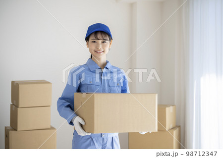 段ボール箱を持った作業服姿の若い女性　引越し業者　イメージ 98712347