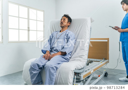 電動リクライニングベッドに寝る男性 98713284