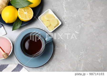 Delicious tea with honey, ginger and lemon on marble table, flat lay. Space for text Delicious tea with honey, ginger and lemon on marble table, flat lay. Space for text 98714103