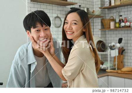 Beautiful young couple enjoying spending time together while standing in modern kitchen 98714732