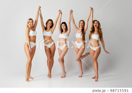 Body-positivity. Studio portrait of cheerful beautiful five women posing in underwear over grey background. Self-care. Concept of natural beauty, body care 98715591